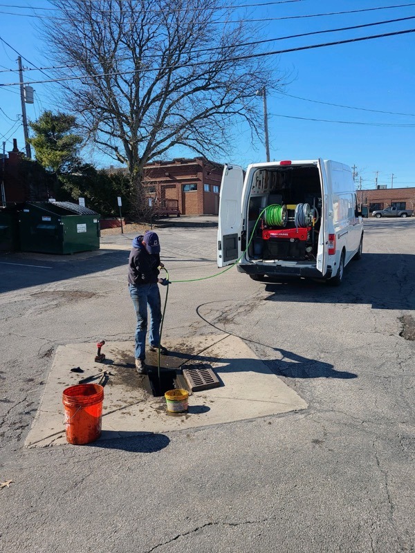 A plumbing expert performing hydro jetting services on a sewer line.